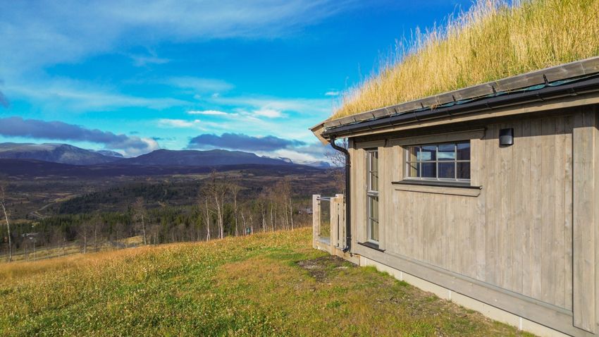 Hytte med torvtak i det åpne fjellandskapet